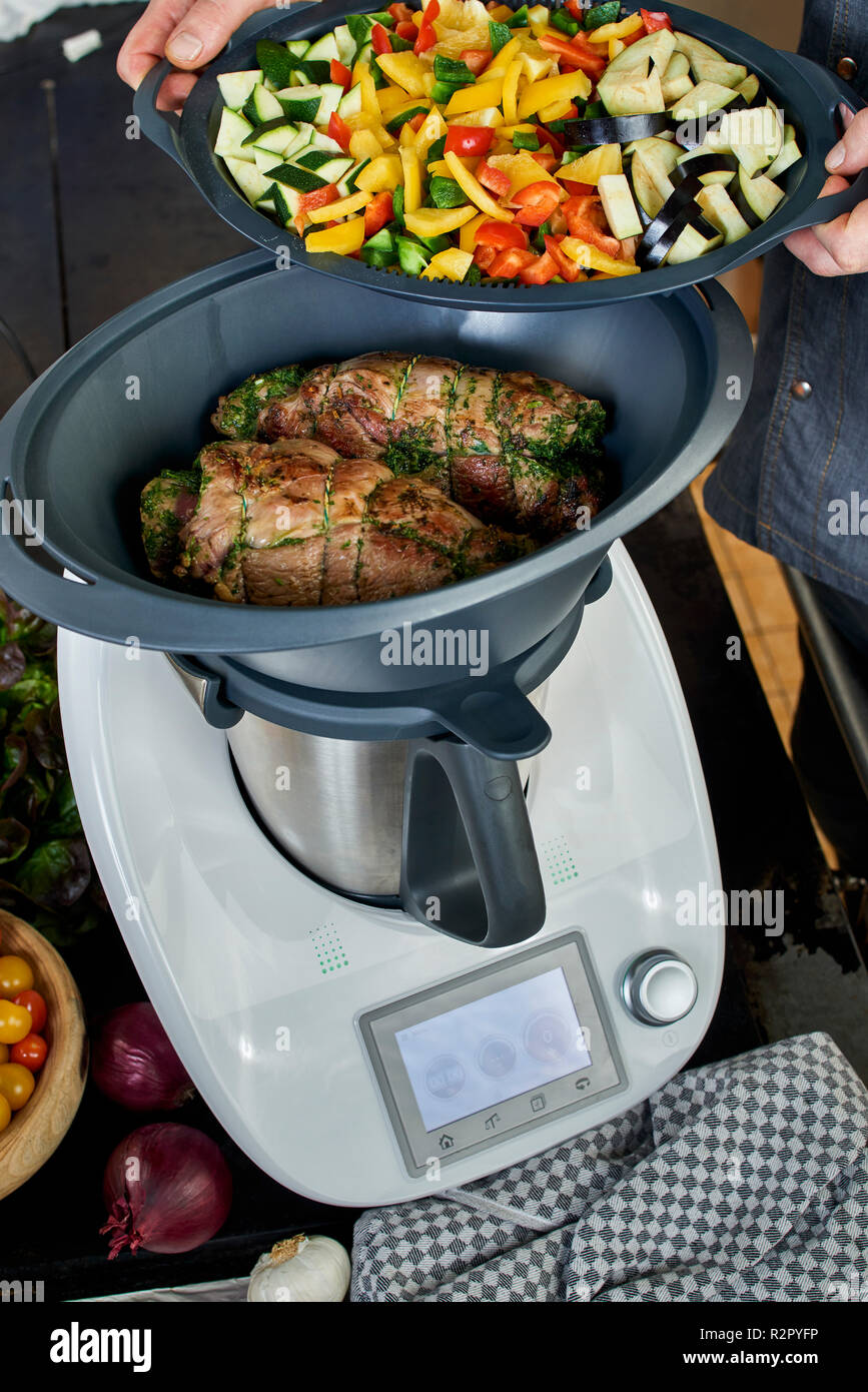 Photo series, step-by-step preparation of a leg of lamb filled with herbs  and Provençal vegetables by using a food processor (Thermomix ® and Varoma  ®), setting the matching tray filled with vegetables
