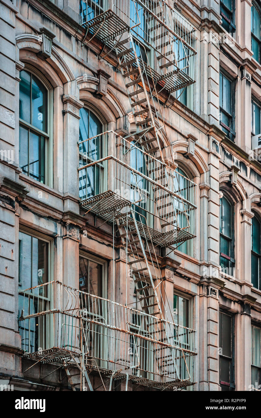 Iron fire escape stairs and balconies on the facade of a building in Soho  area of New York City Stock Photo - Alamy