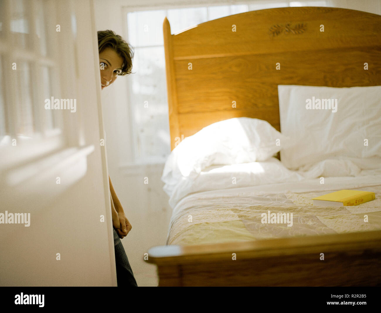 Mature Woman Peeking From Behind The Wall In Her Bedroom Stock Photo mature-woman-peeking-from-behind-the-wall-in-her-bedroom-stock-photo