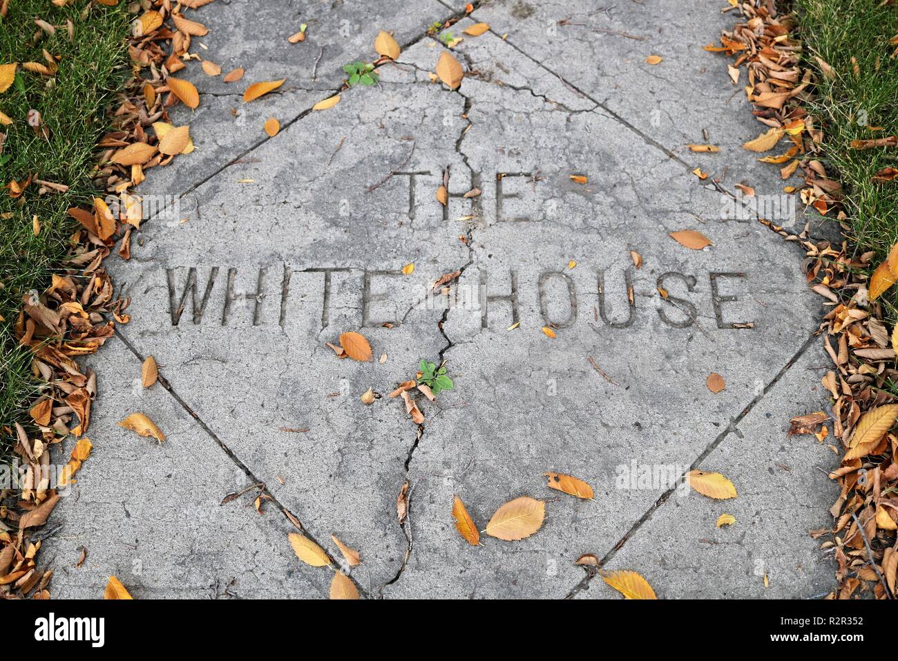 A sidewalk adorning 'the white house' with a crack going down the middle. Stock Photo