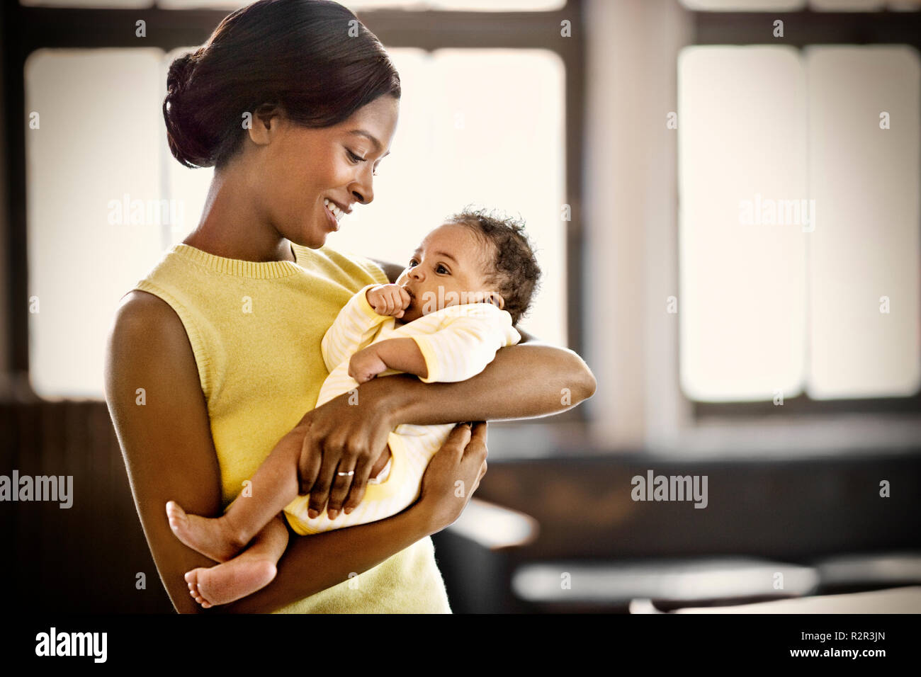 Smiling young mother holding her baby. Stock Photo