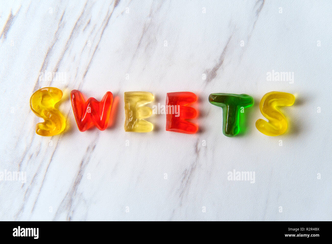 Assorted colorful gummy candy letters spell the word Sweets Stock Photo