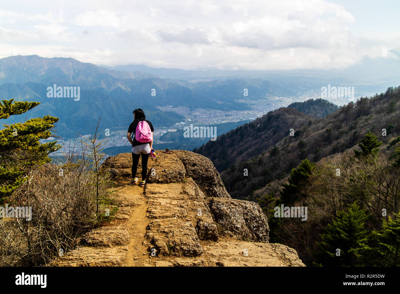 A woman admiring the spectacular view after a long hike taken from the mountains surrounding Mt. Fuji Stock Photo