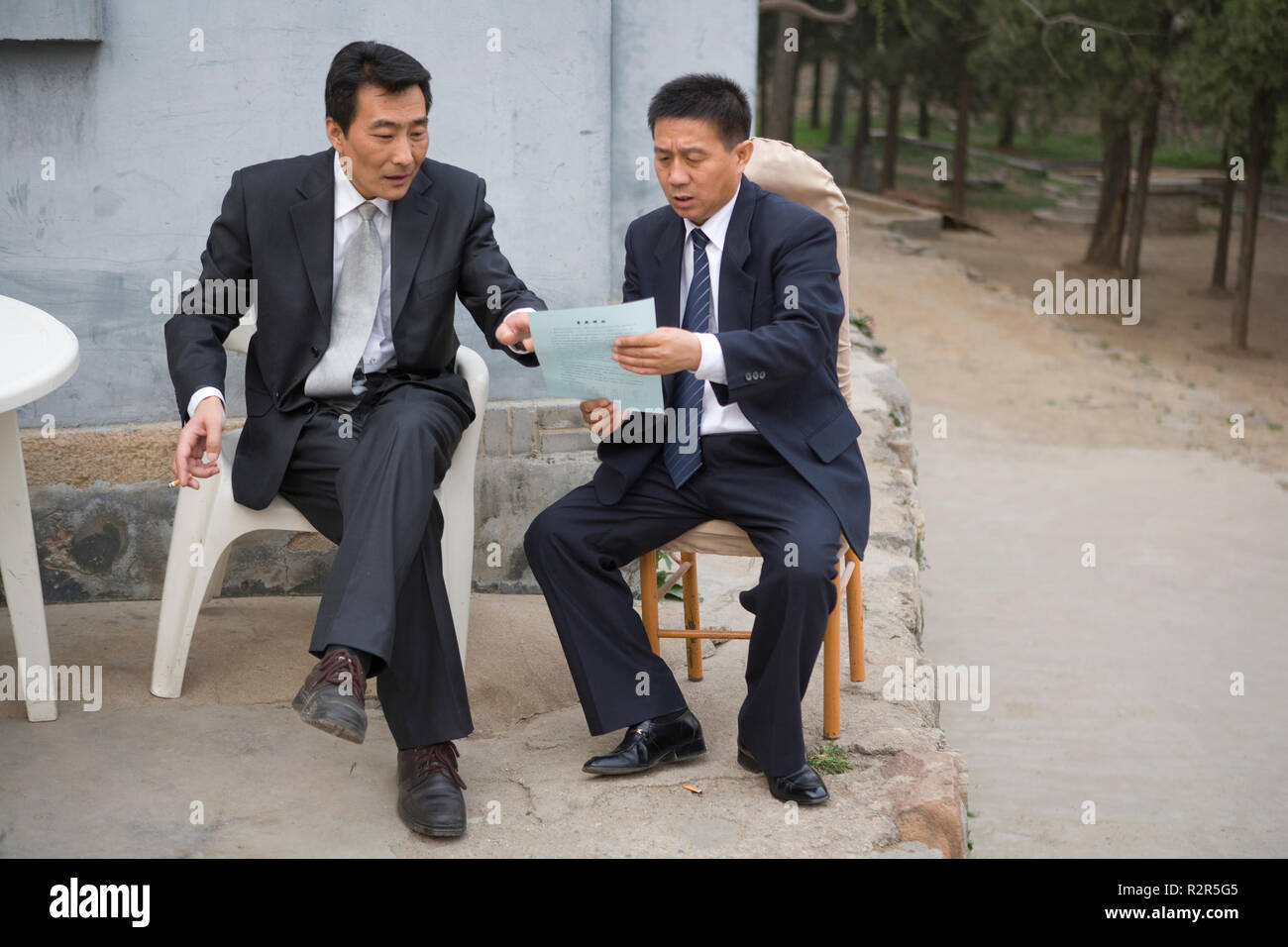 Two businessmen having a discussion while looking at a document. Stock Photo