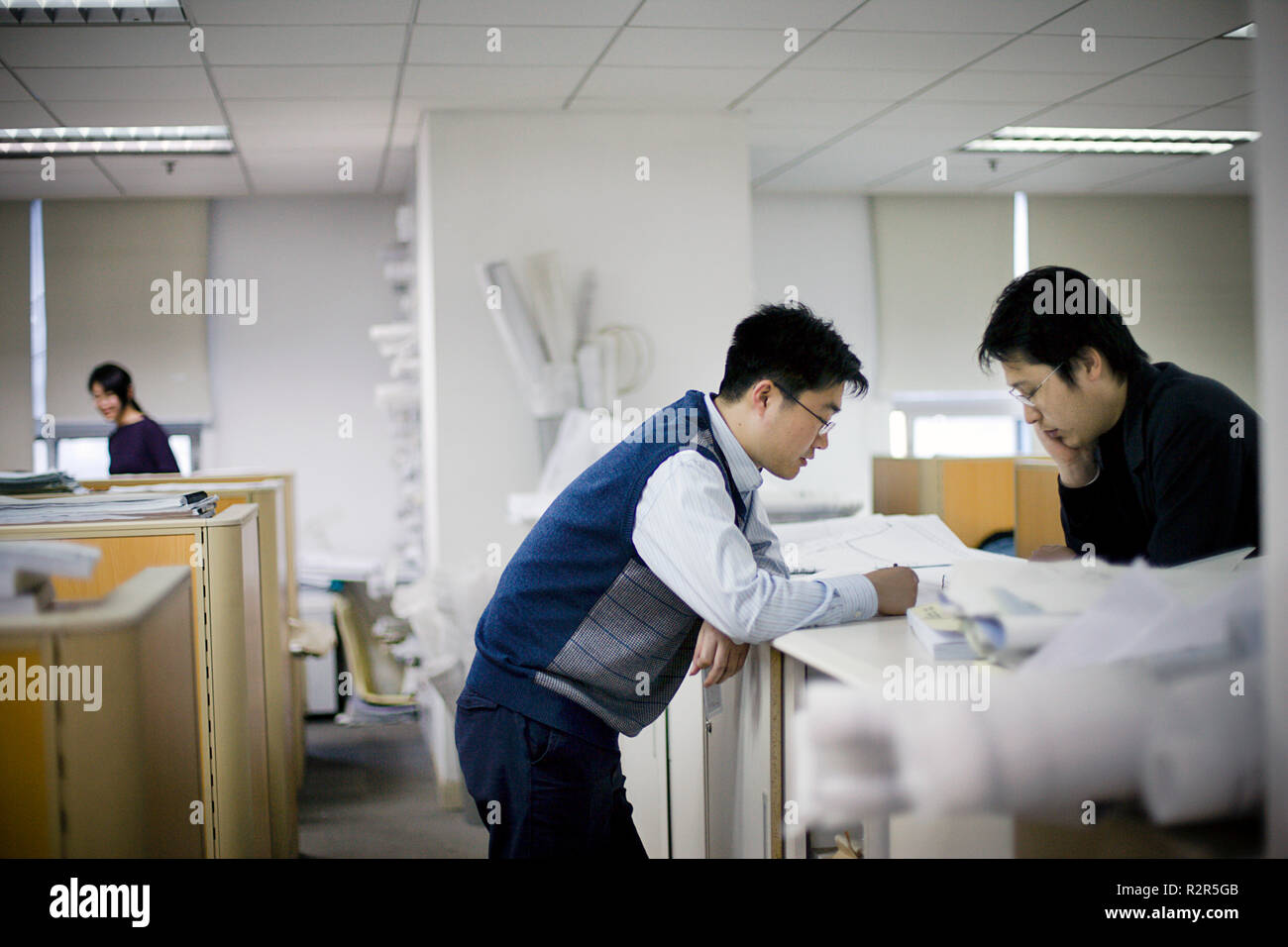 Two young businessmen looking at documents inside an office. Stock Photo