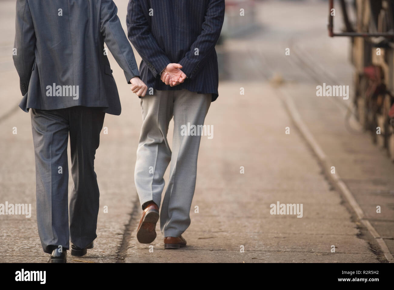 Legs of businessmen walking along a shipping yard. Stock Photo