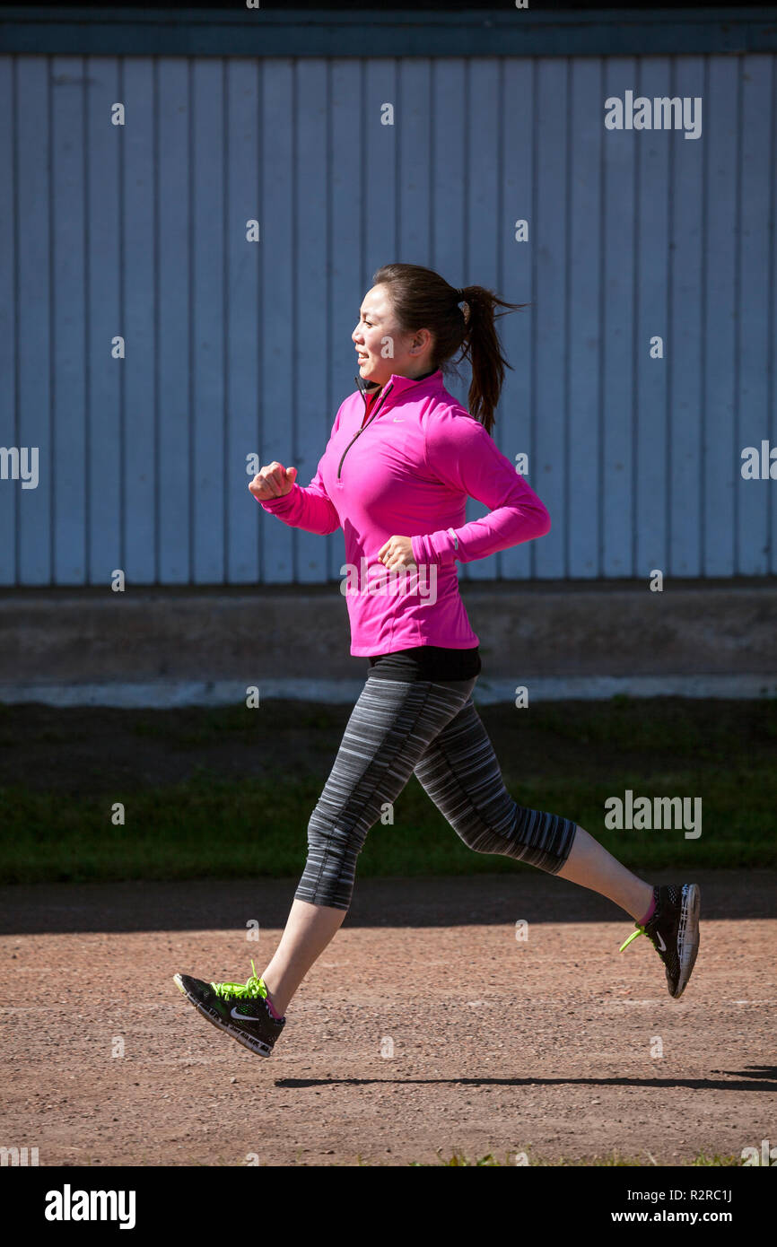 WA14618-00...WASHINGTON - Young asian woman jogging in a city of Edmonds park. MR# S12 Stock Photo