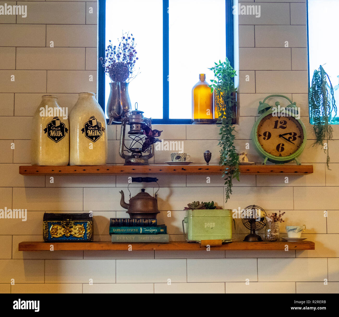 Ceramic milk bottles clock and kettle on wooden shelves Stock Photo Alamy