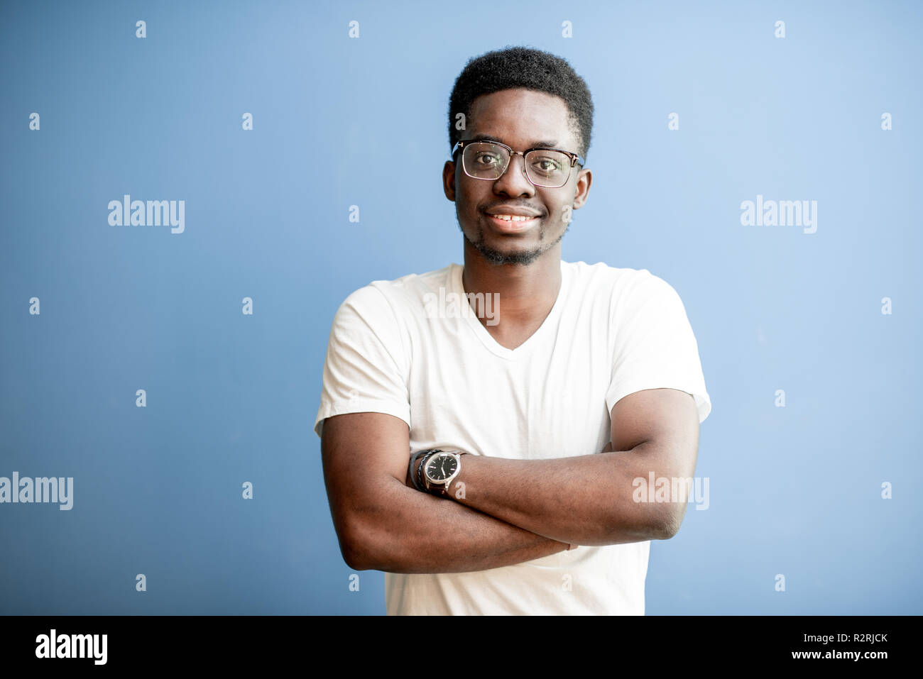 Portrait of a young african man dressed in white t-shirt standing on ...
