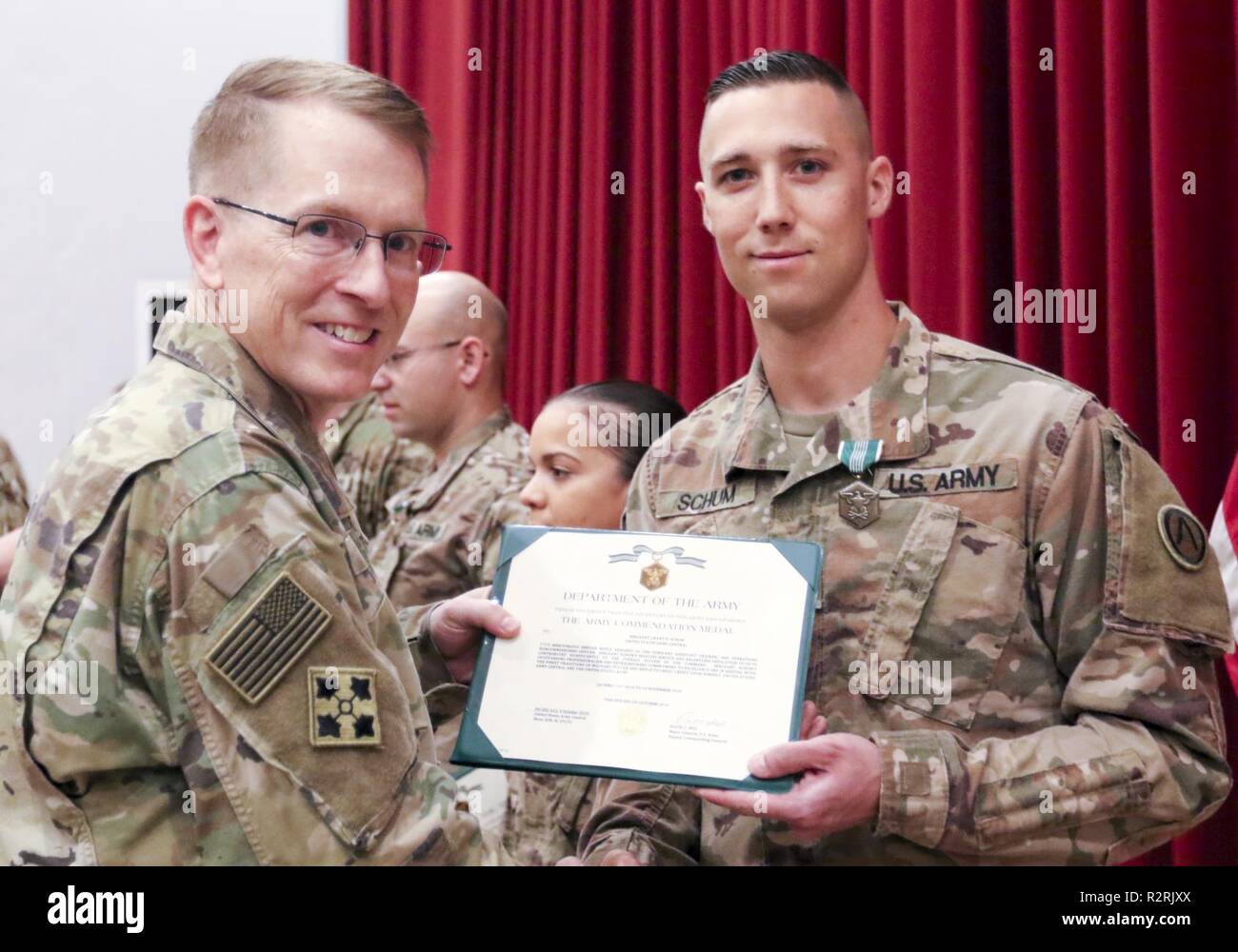 U.S Army Maj. Gen. David C. Hill, U.S. Army Central's deputy commanding general, presents the Army Commendation Medal to Massachusetts Army National Guard Sgt. Grant D. Schum, USARCENT forward assistant training and operations non-commissioned officer, at Camp Arifjan, Kuwait, Nov. 5, 2018. End of tour awards foster an environment of persistent excellence in our military. Stock Photo