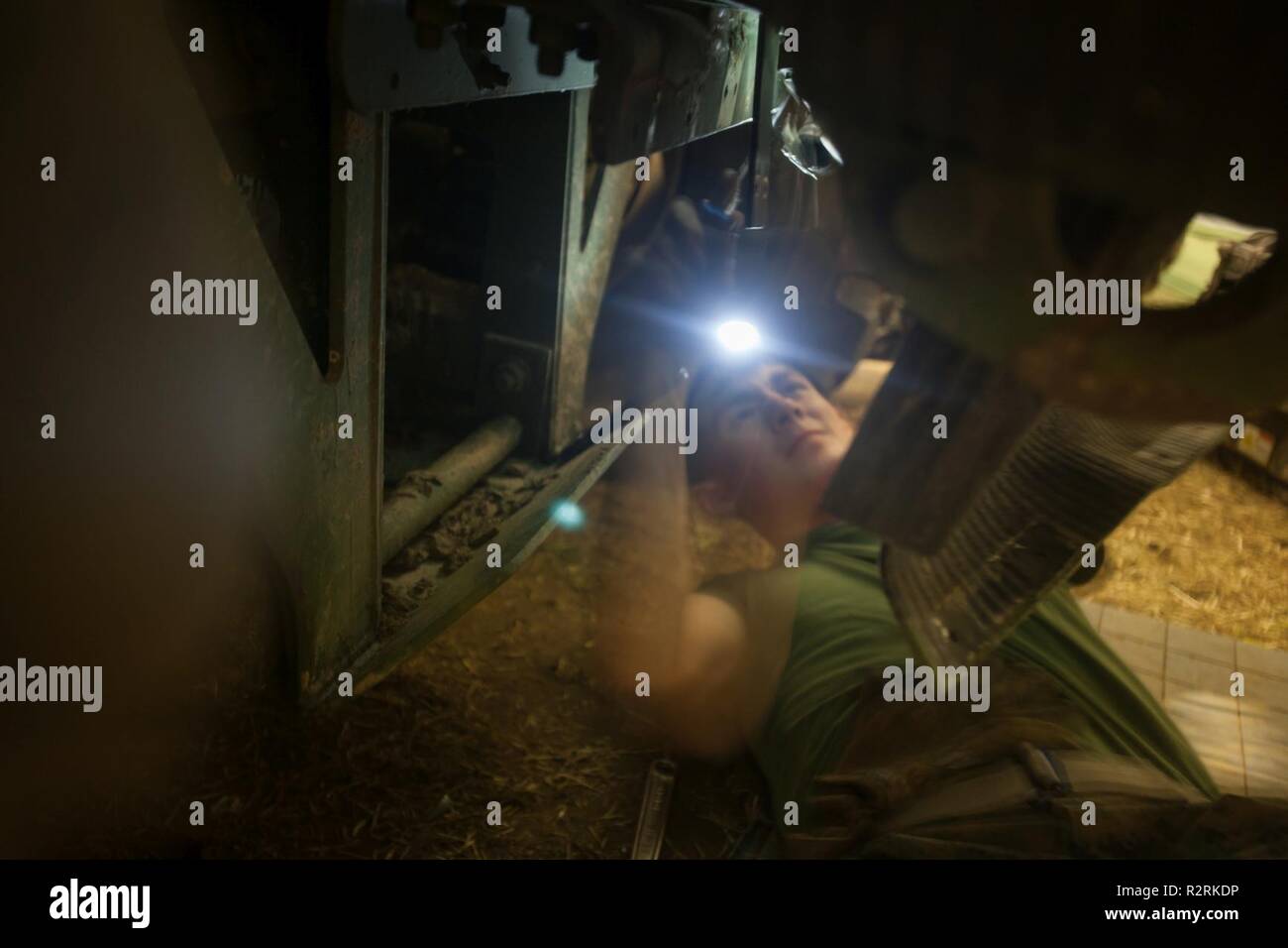 U.S. Marine Corps Lance Cpl. Kevin Kubinak, with Combat Logistics Battalion 251 (CLB 251), 2nd Marine Logistics Group-Forward, works underneath a Medium Tactical Vehicle Replacement wrecker in Voll, Norway, Nov. 1, 2018. Marines of CLB 251 provided mechanic support to the units of 2nd Marine Logistics Group-Forward during Exercise Trident Juncture 18. The exercise enhances the U.S. and NATO Allies’ and partners’ abilities to work together collectively to conduct military operations under challenging conditions. Stock Photo