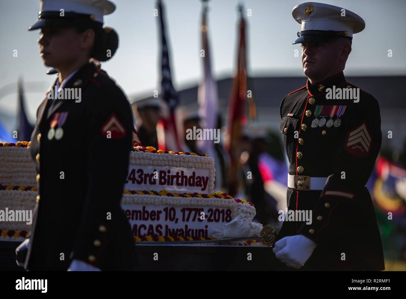 U.S. Marines with Headquarters and Headquarters Squadron (H&HS) carry a Marine Corps birthday cake during the 243rd Marine Corps birthday uniform pageant at Marine Corps Air Station Iwakuni, Japan, Nov. 5, 2018. The annual ceremony was held in honor of the 243rd Marine Corps birthday. It included a historical uniform pageant to honor Marines of the past, present and future while signifying the passing of traditions from one generation to the next. Stock Photo
