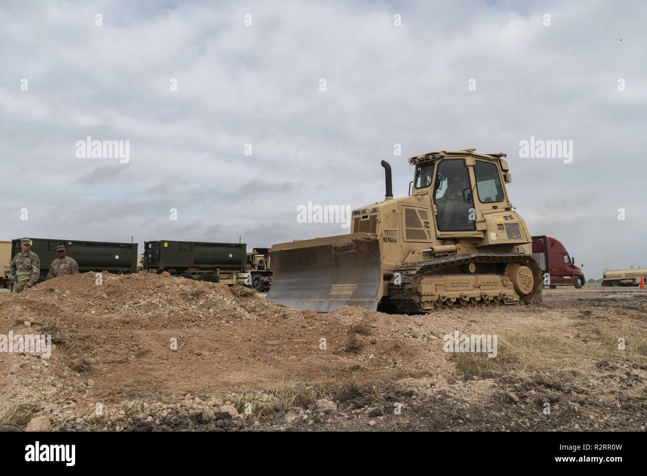 Pfc. Anthony Ricottilli, a Beacon, New York native, and a horizontal construction engineer, with the 887th Engineer Support Company, create a ramp for the unit to download their vehicles from long-bed trailers, Nov. 5 in Donna, Texas. U.S Northern Command is providing military support to the Department of Homeland Security and U.S. Customs and Border Protection to secure the southern border of the United States. Stock Photo