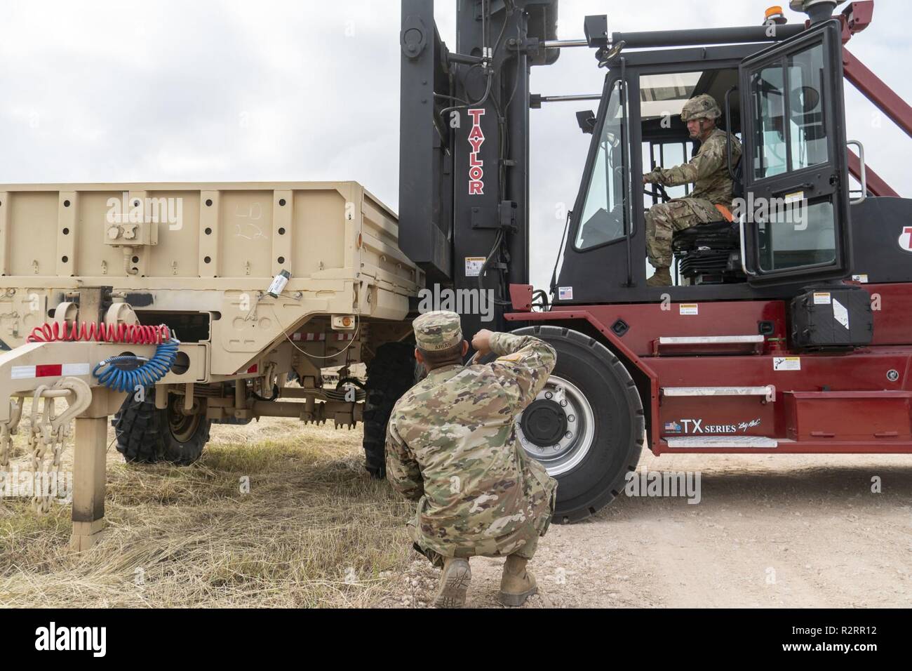 Spc. Daniel Arias, an Anaheim, California native, and wheeled vehicle mechanic with the 372nd Inland Cargo Transfer Company, guides a forklift operator as they download the unit's military vehicles, Nov. 5 in Donna Texas. U.S Northern Command is providing military support to the Department of Homeland Security and U.S. Customs and Border Protection to secure the southern border of the United States. Stock Photo