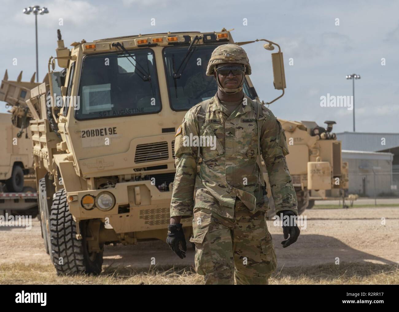 Pvt. Lamark Miller, a Montgomery, Alabama native and a horizontal construction engineer with the 887th Engineer Support Company, ground guides vehicles to the staging area, Nov. 5 in Donna, Texas. U.S. Northern Command is providing military support to the Department of Homeland Security and U.S. Customs and Border Protection to secure the southern border of the United States. Stock Photo