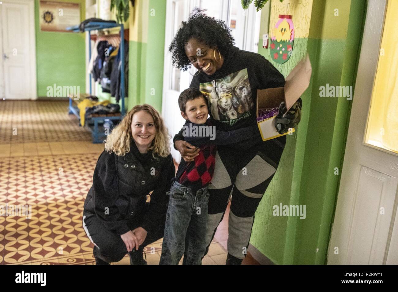 Spc. Kristina Brown (left) and Ssg. Brandi Rhone of the 278th ACR from Tennessee plays with a child from the Academic Rehabilitation Center for Children with Special Needs, Nov. 7. Stock Photo