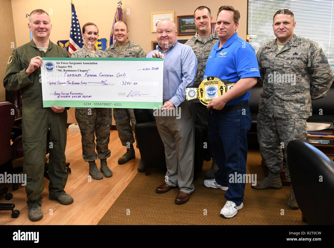 Kevin Ott, center, the Air Force Sergeants Association Chapter 951 special event coordinator, presents a check to Col. Eric Hresko, the 28th Bomb Wing vice commander, during the annual Combined Federal Campaign fundraising event at Ellsworth Air Force Base, S.D., Nov. 6, 2018. AFSA Chapter 951 donated more than $3,000 to two different CFC charities: the Gary Sinise Foundation and the Intrepid Fallen Heroes Campaign. Stock Photo