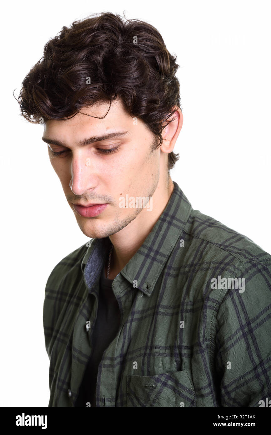 Face of young handsome man thinking while looking down Stock Photo