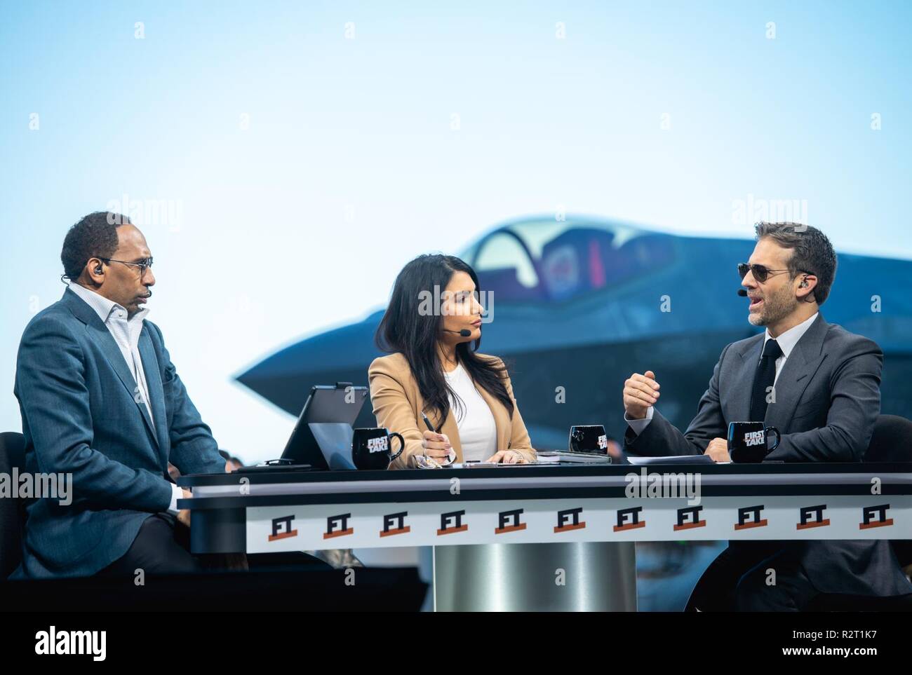 ESPN First Take hosts, Stephen A. Smith, Molly Qerim Rose and Max Kellerman, debate various sports topics during a live show at Luke Air Force Base, Ariz. Nov. 9, 2018. As part of an annual initiative, ESPN First Take televises their live show on military installations to honor military service members near Veterans Day. Stock Photo