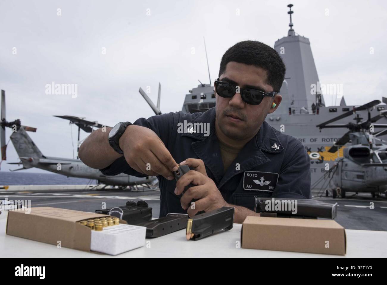 PACIFIC OCEAN (Nov. 7, 2018) - Aviation Ordnanceman 3rd Class Cody Soto, from Goliad, Texas, loads rounds into a magazine during a small arms weapons qualification on the flight deck of the amphibious transport dock ship USS Green Bay (LPD 20). Green Bay, part of Commander, Amphibious Squadron 11, is operating in the region to enhance interoperability with partners and serve as a ready-response force for any type of contingency. Stock Photo