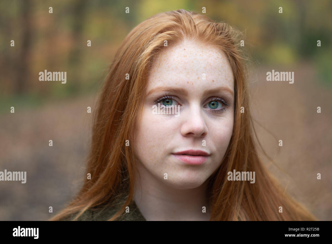 A Portrait of a red haired girl in a park in autumn Stock Photo