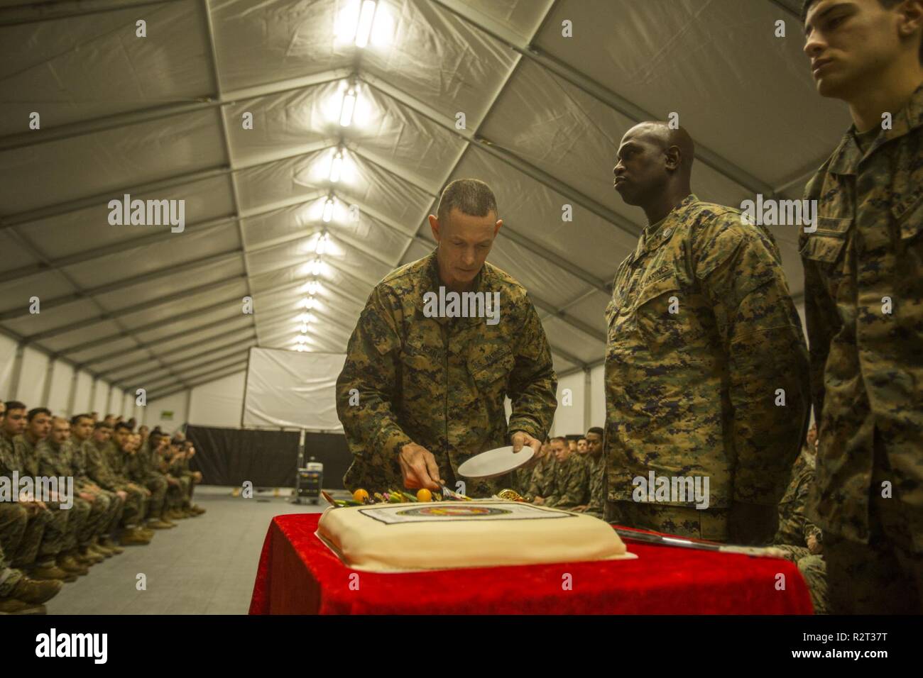 U.S. Marine Corps Brig. Gen. Stephen M. Neary, the deputy commanding general of II Marine Expeditionary Force, cuts a piece of ceremonial cake to give to the oldest and youngest Marines present during a ceremony celebrating the Marine Corps’ 243rd birthday on Vaernes Air Station, Norway, Nov. 10, 2018. The ceremony is held at the conclusion of Exercise Trident Juncture 18, an exercise in place to enhance the U.S. and NATO Allies’ and partners’ abilities to work together collectively to conduct military operations under challenging conditions. Stock Photo