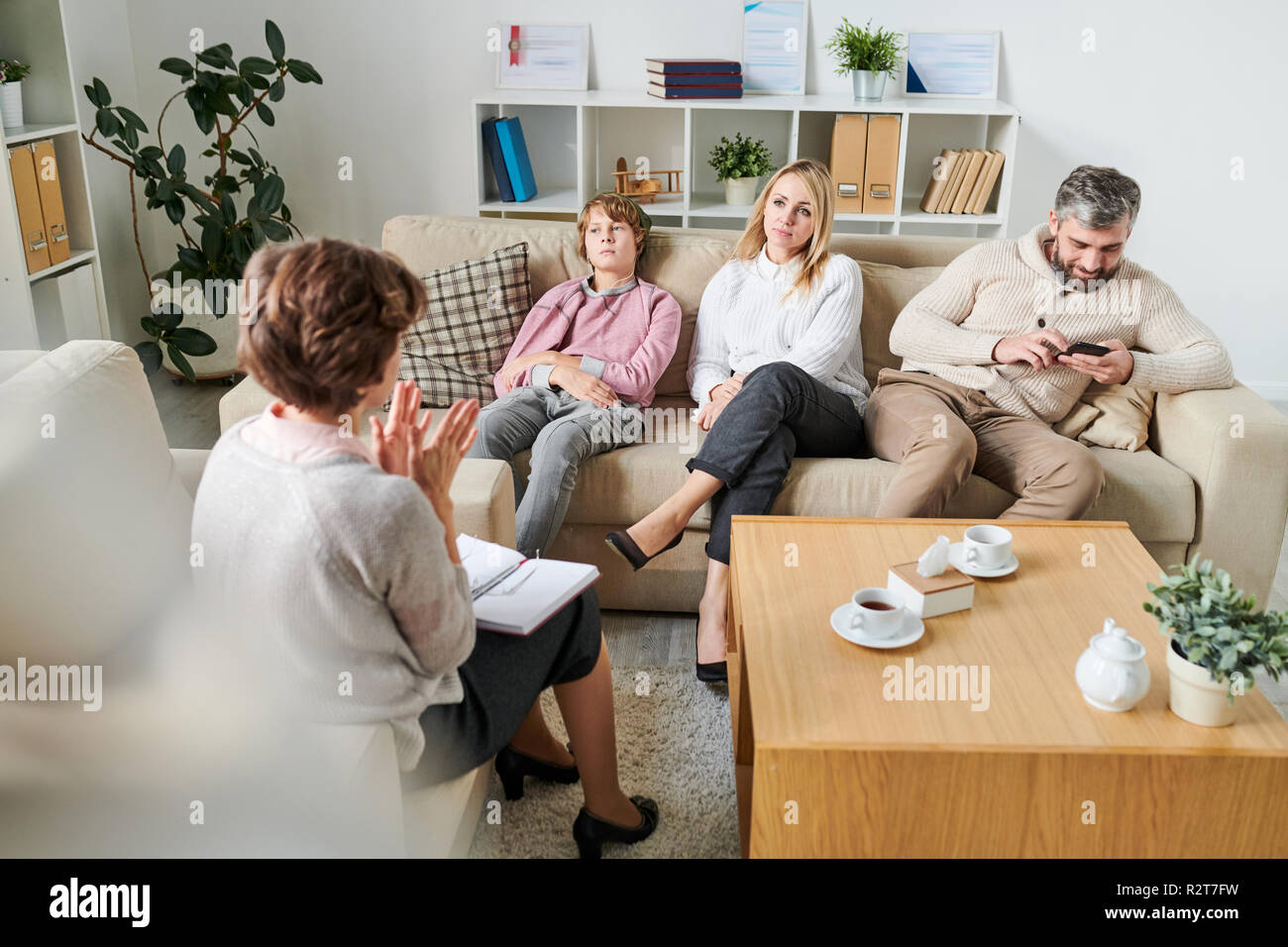 Psychologist explaining situation to family at session Stock Photo