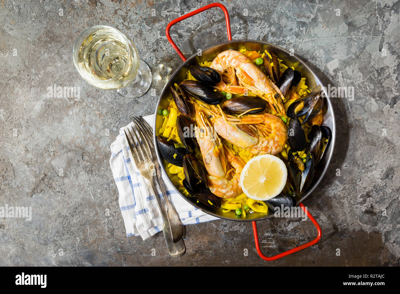 Traditional spanish seafood paella in a fry pan over gray background