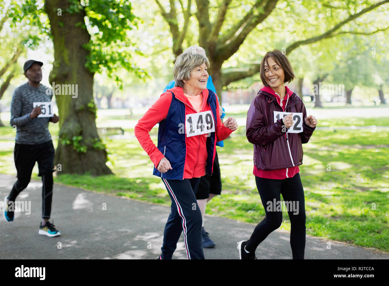 Active senior women friends power walking sports race in park Stock Photo