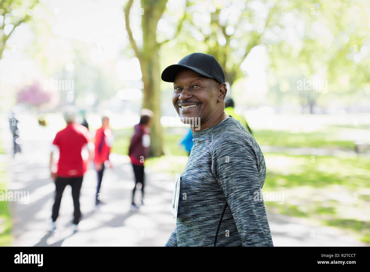 Portrait confident, happy senior man walking sports race in park Stock Photo