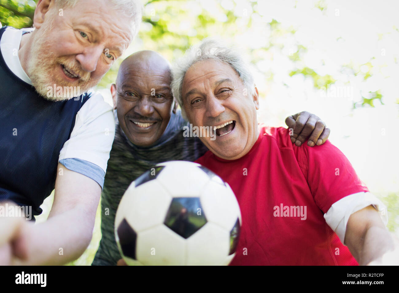 Portrait active senior men friends playing soccer Stock Photo