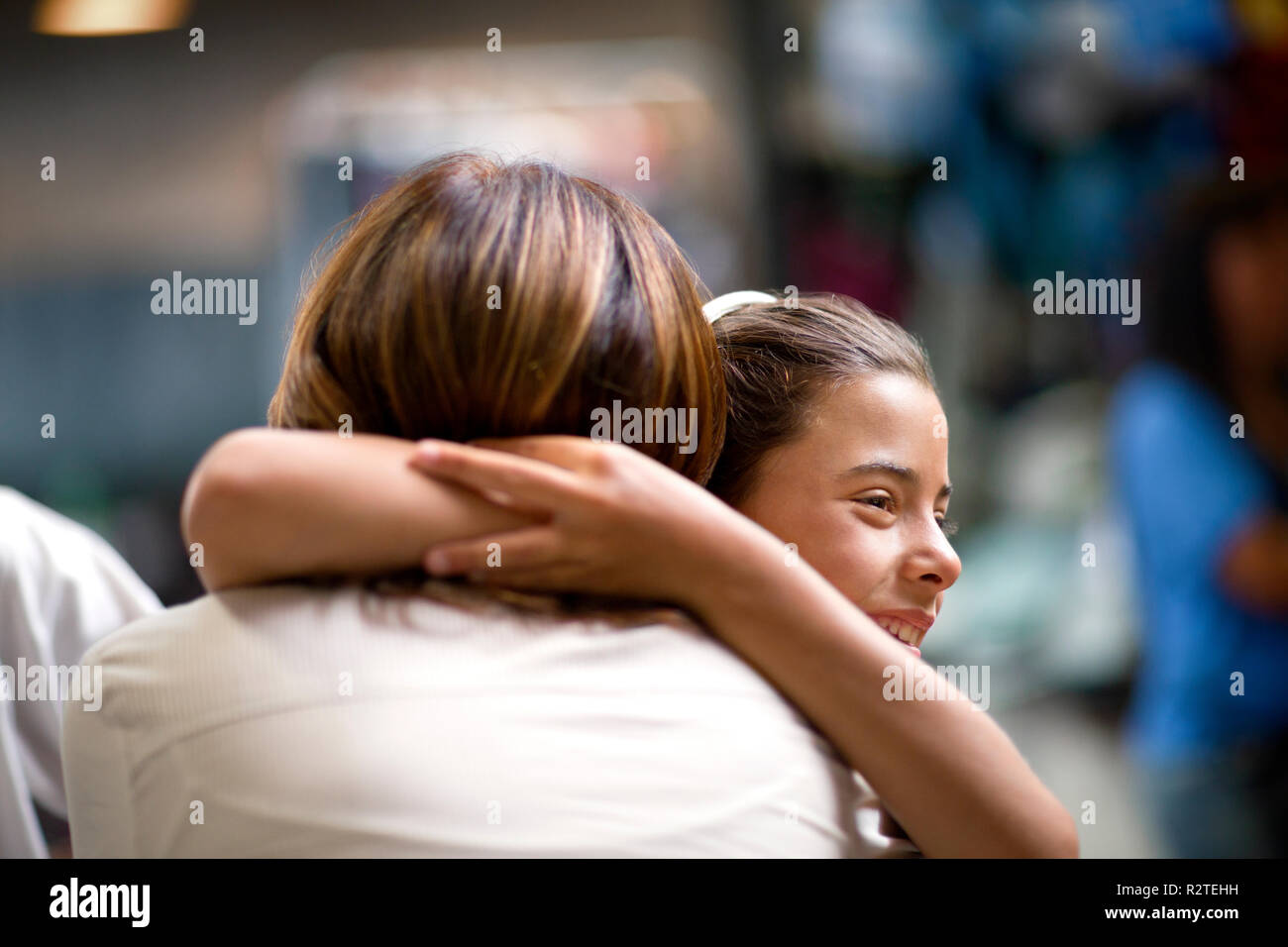Portrait of woman receiving a hug from her granddaughter Stock Photo