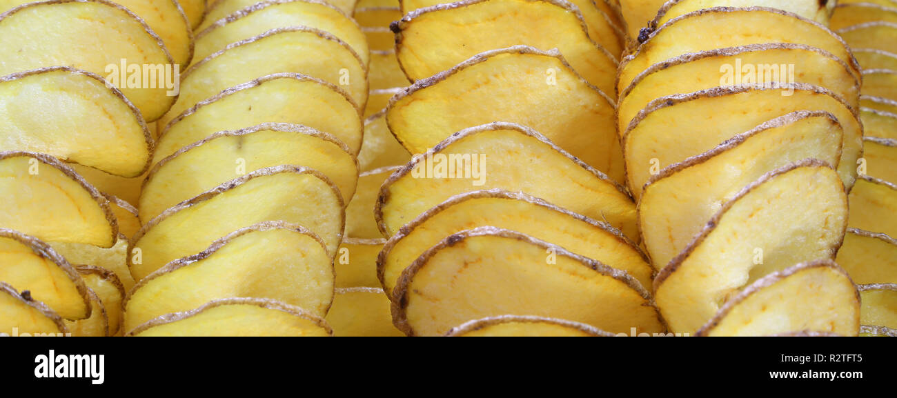 background of yellow sliced fried potatoes with peel Stock Photo - Alamy