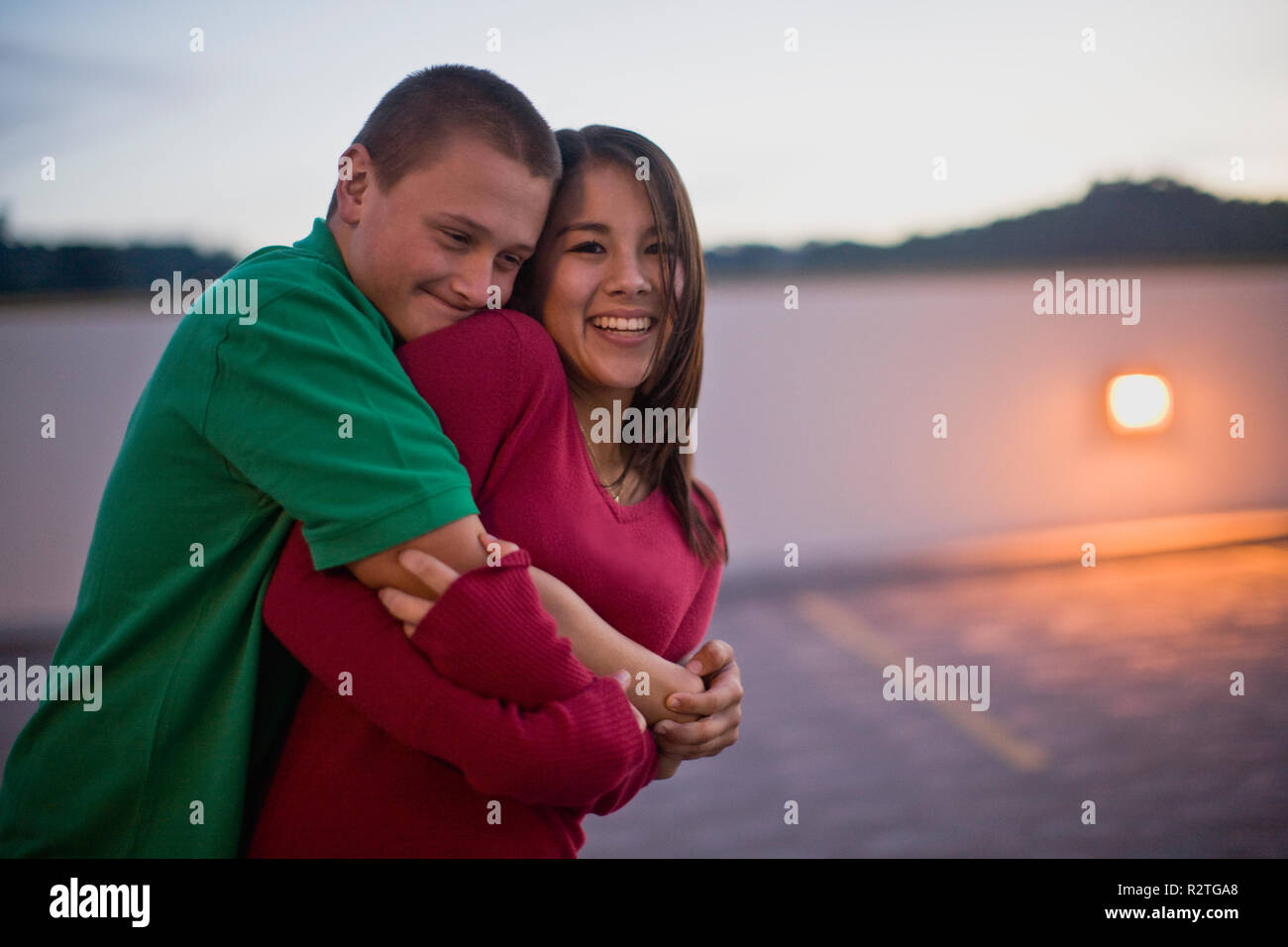 Hugging A Lod Teenage couple hugging in an empty parking lot Stock Photo - Alamy