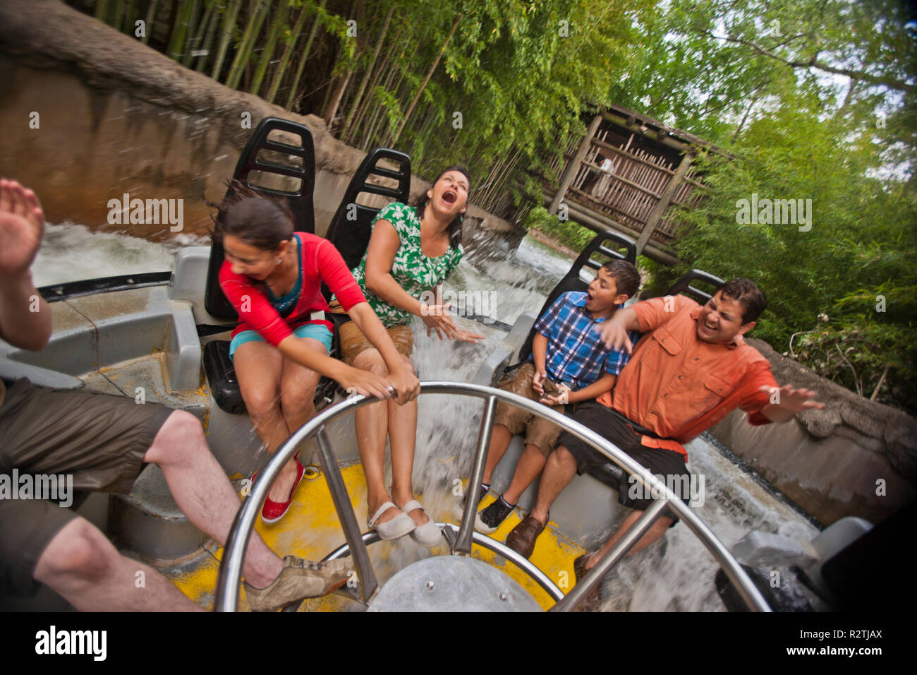 Smiling family riding on a water ride at an amusement park. Stock Photo