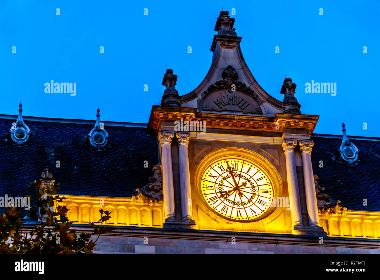 The lighted clock of Cercle Cité Luxembourg at night in the heart of