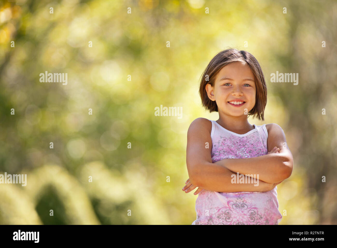 Portrait of a smiling young girl with her arms crossed Stock Photo - Alamy