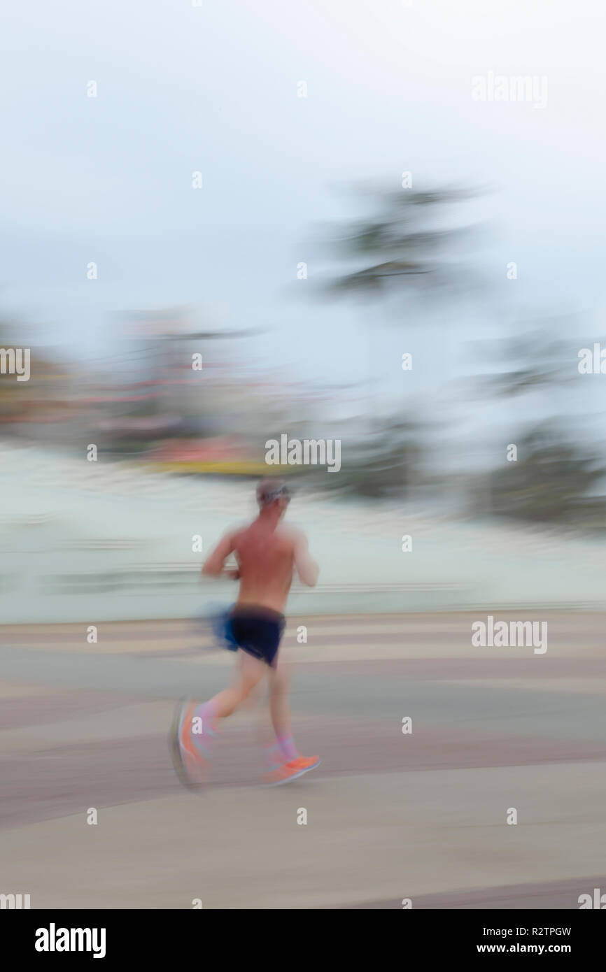 An early morning jogger puts in some hard work on Durban's beachfront boardwalk to keep himself in shape. Stock Photo