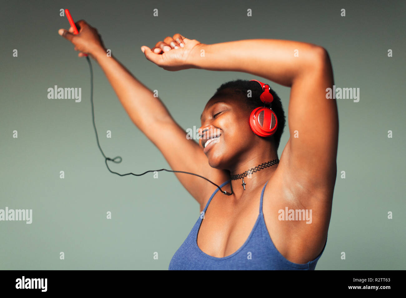 Carefree young woman with headphones and mp3 player dancing Stock Photo