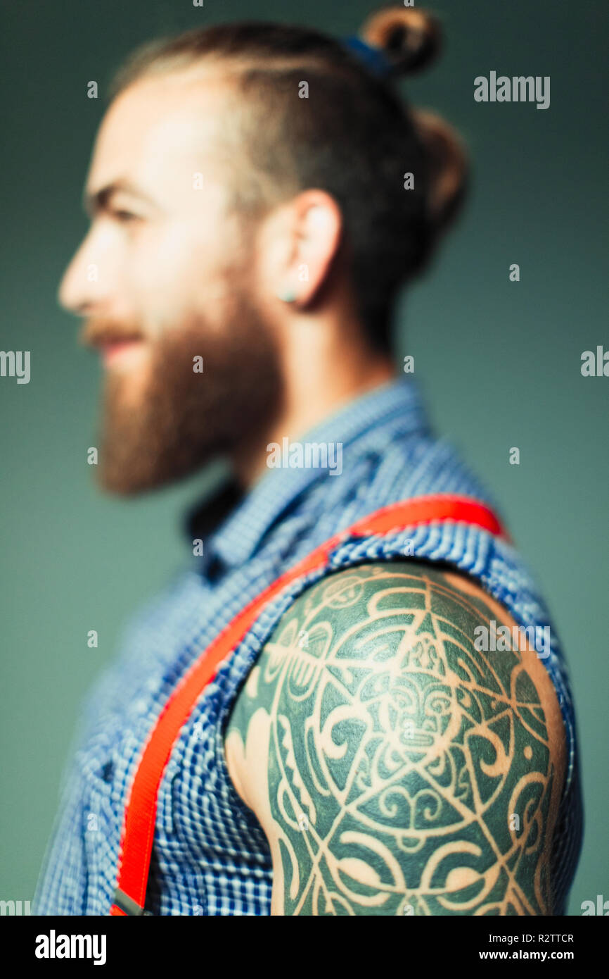 Close up hipster man with shoulder tattoo and beard Stock Photo