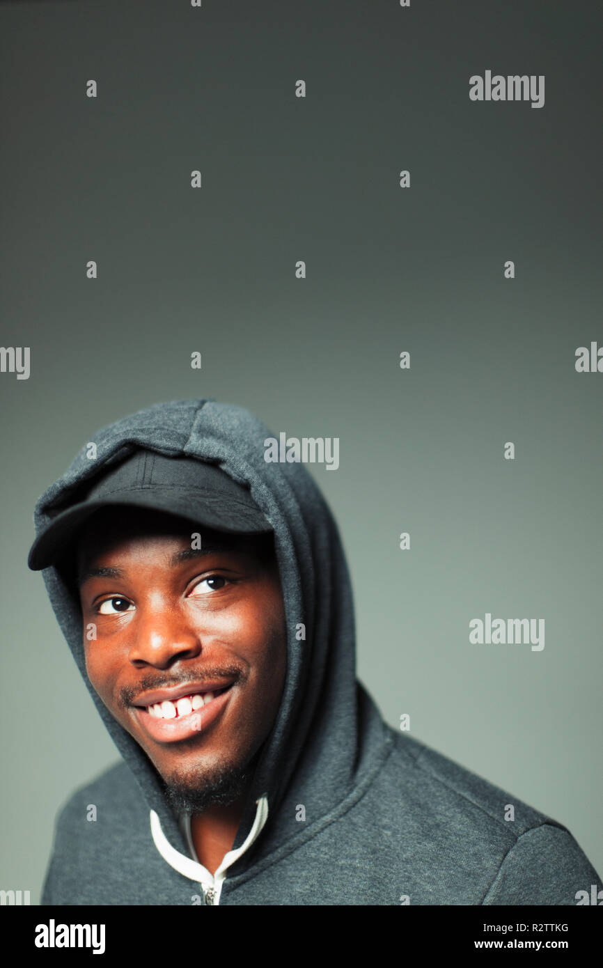 Portrait confident, smiling teenage boy in hoody looking up Stock Photo