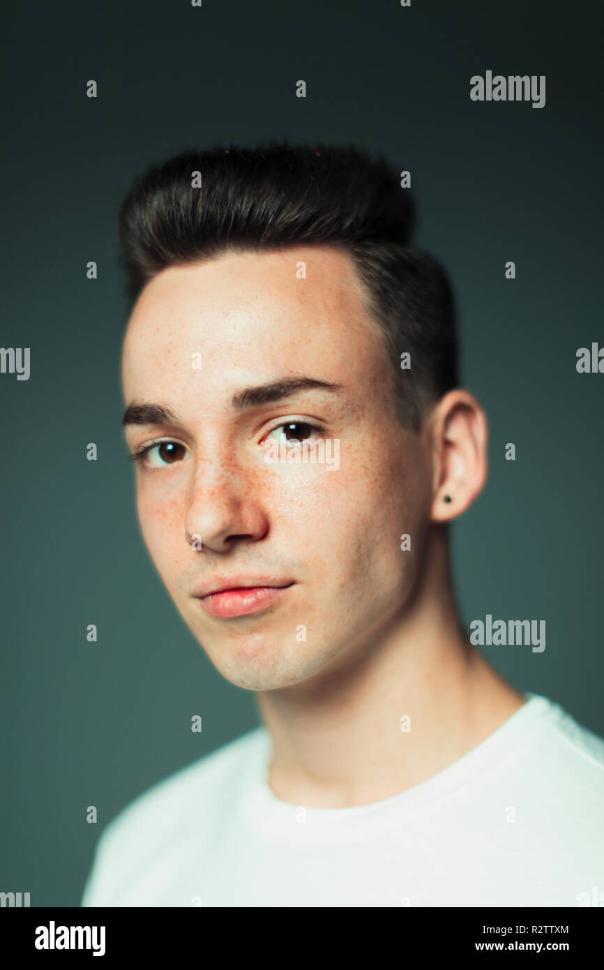 Portrait confident teenage boy with freckles and earring Stock Photo