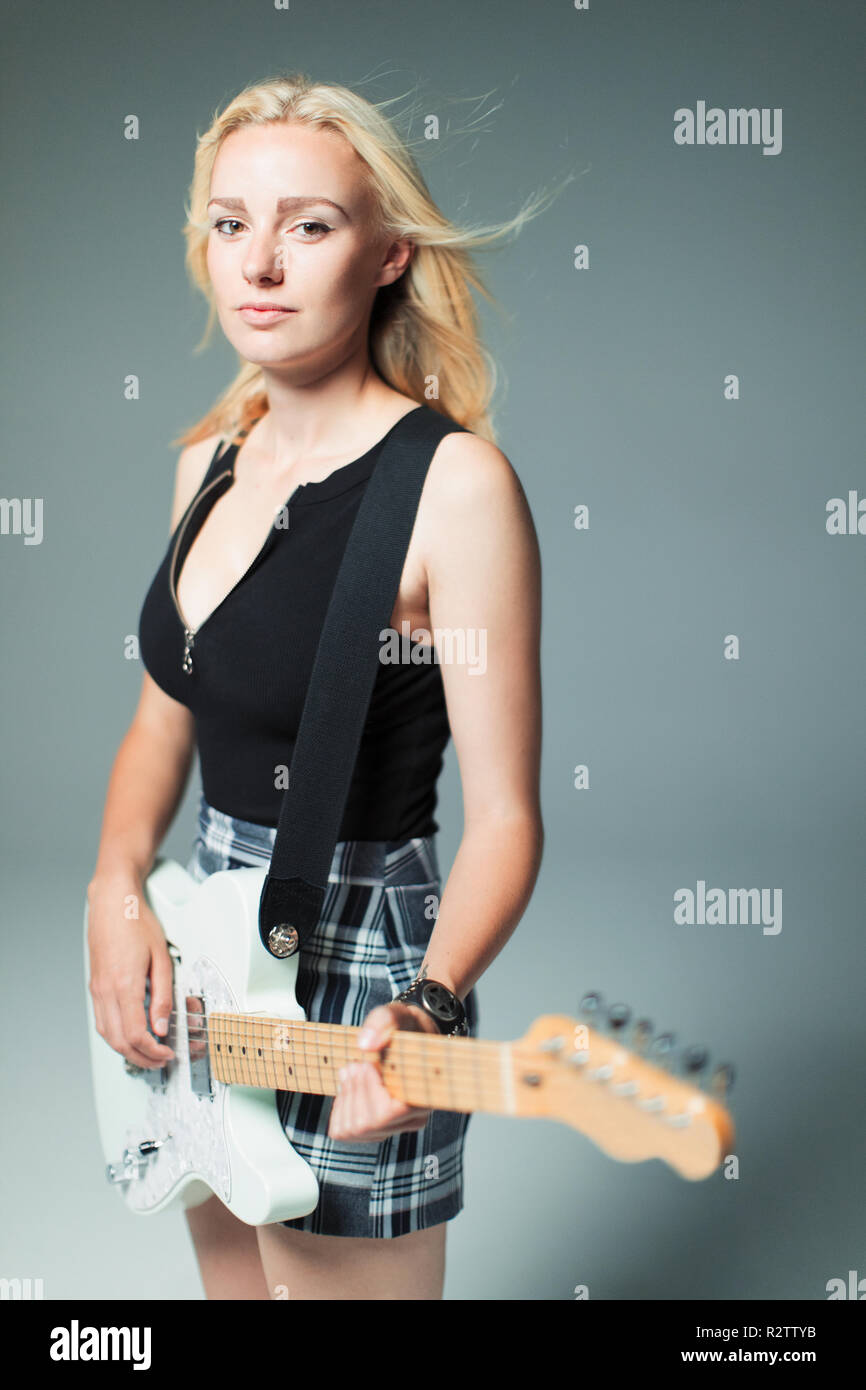Portrait confident, cool young woman playing electric guitar Stock Photo