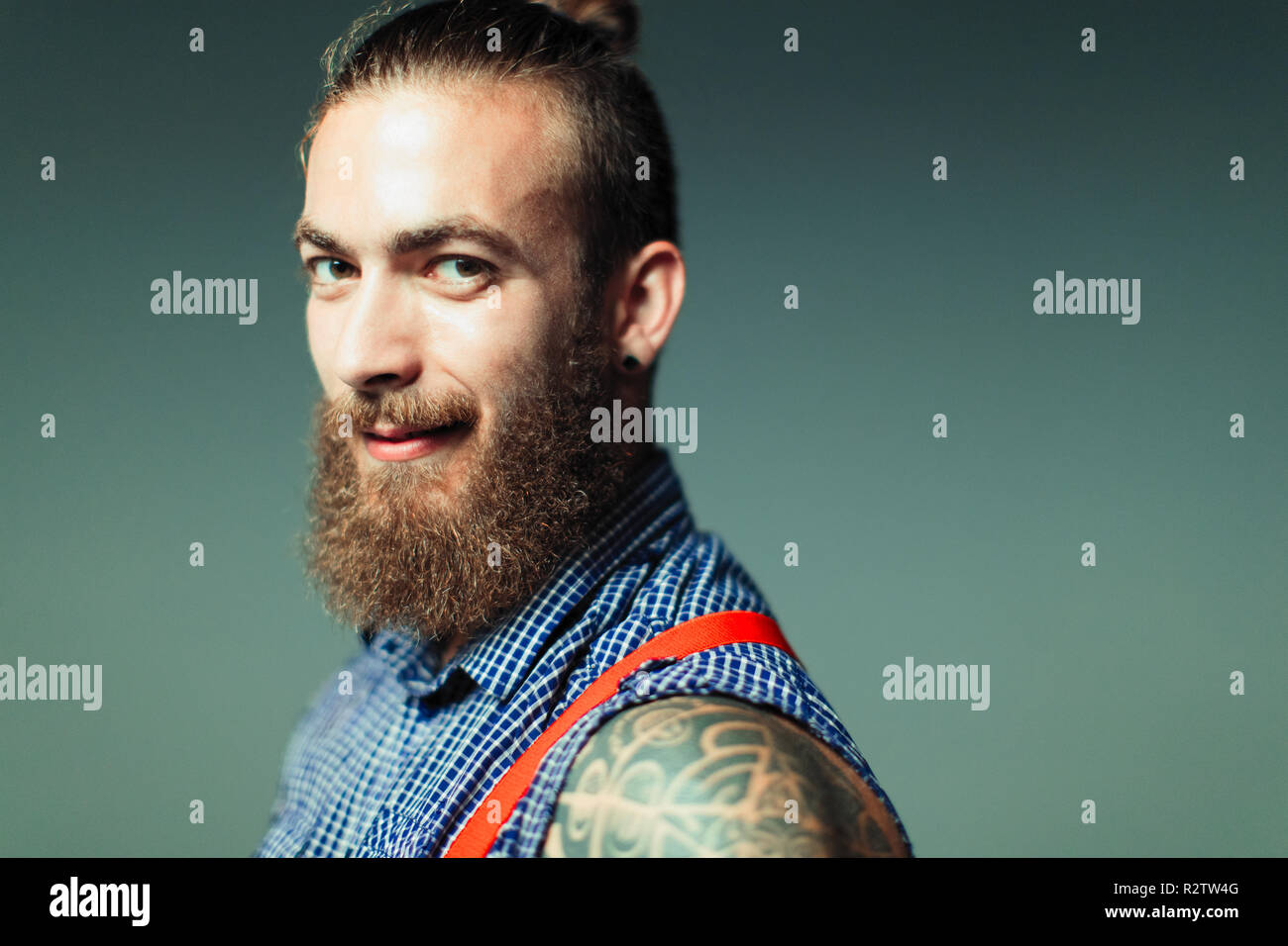 Portrait confident, cool male hipster with beard and shoulder tattoo Stock Photo