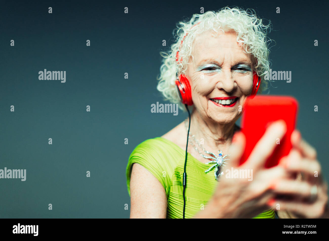 Carefree senior woman with headphones and mp3 player listening to music Stock Photo