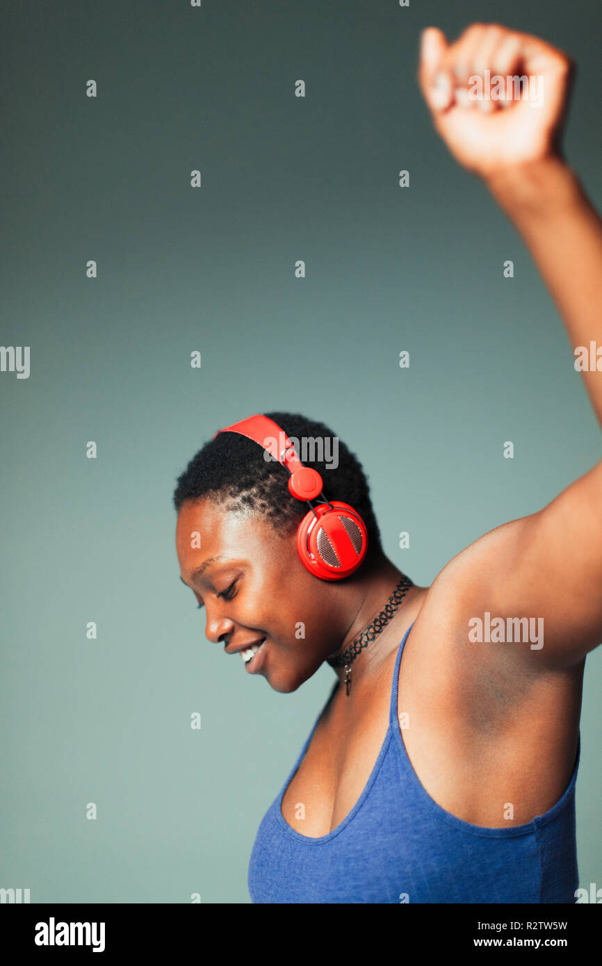 Carefree woman with headphones dancing, listening to music Stock Photo
