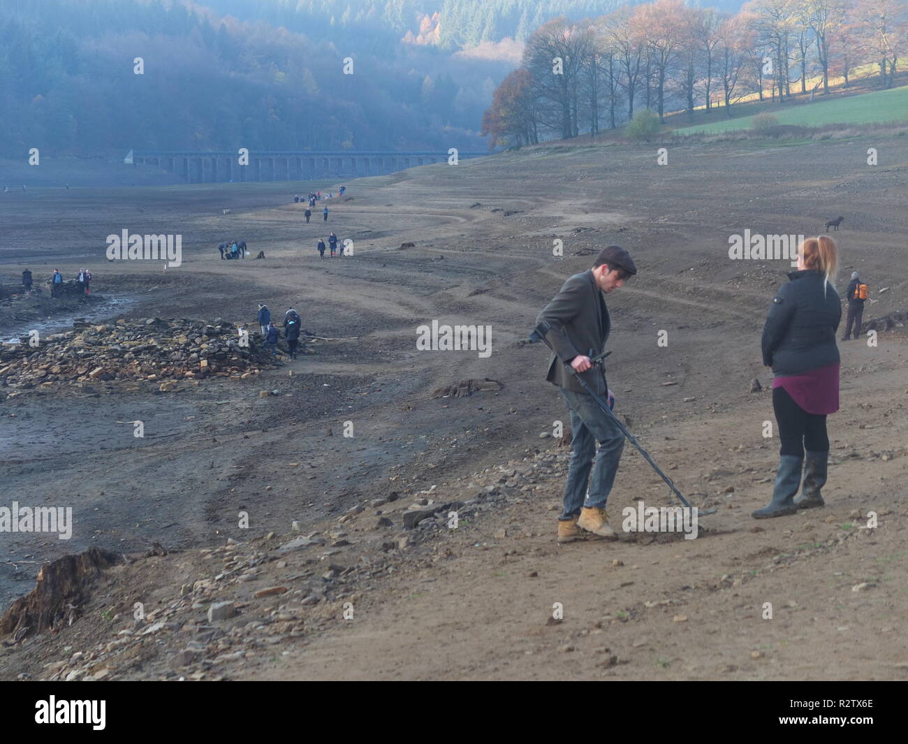 Curious crowds inc metal detector explore what normally bottom of Ladybower Reservoir and remains of Derwent Village, exposed following 2018 heatwave Stock Photo