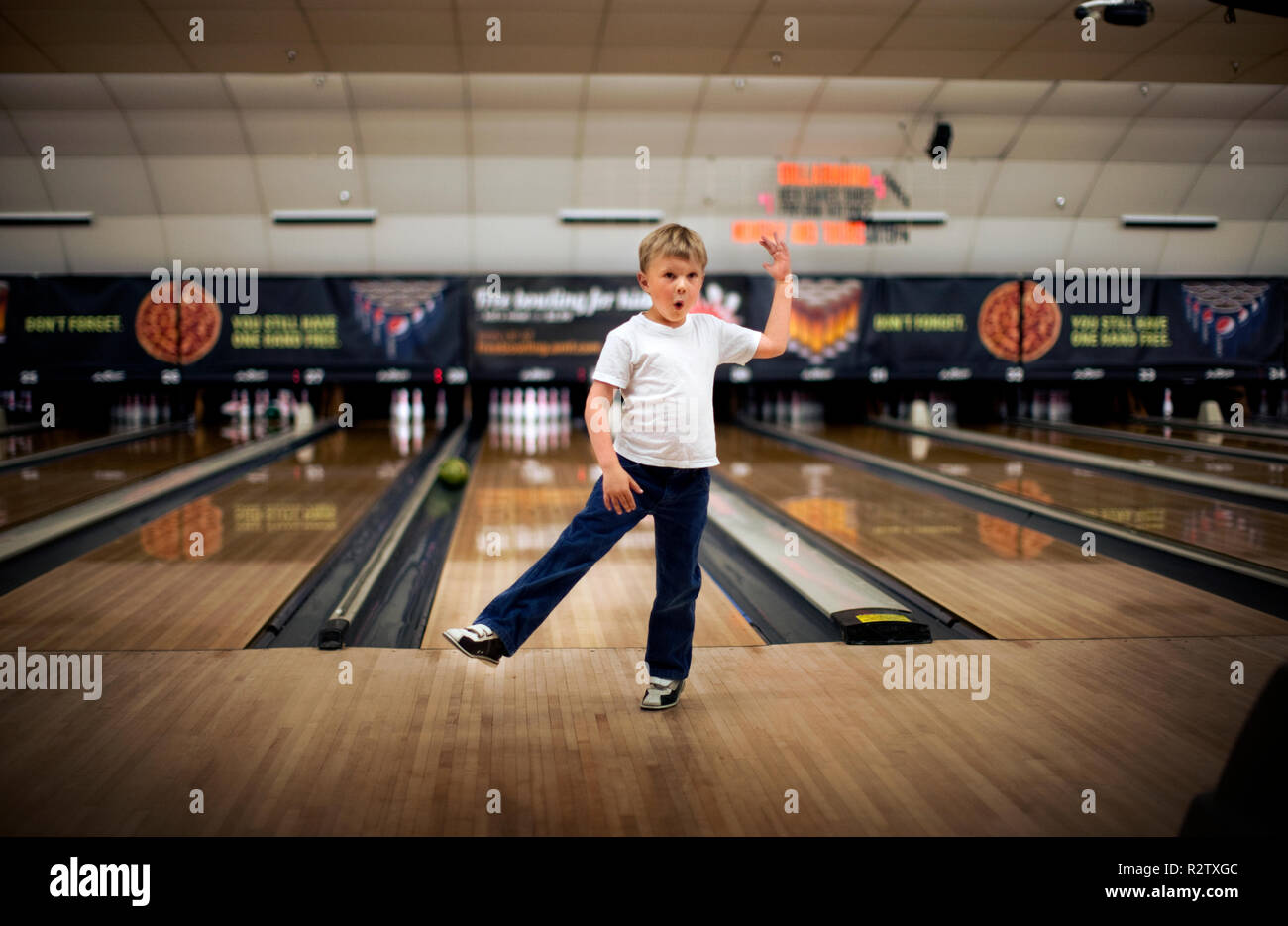 Boy stands on one leg infront of a bowling alley Stock Photo Alamy