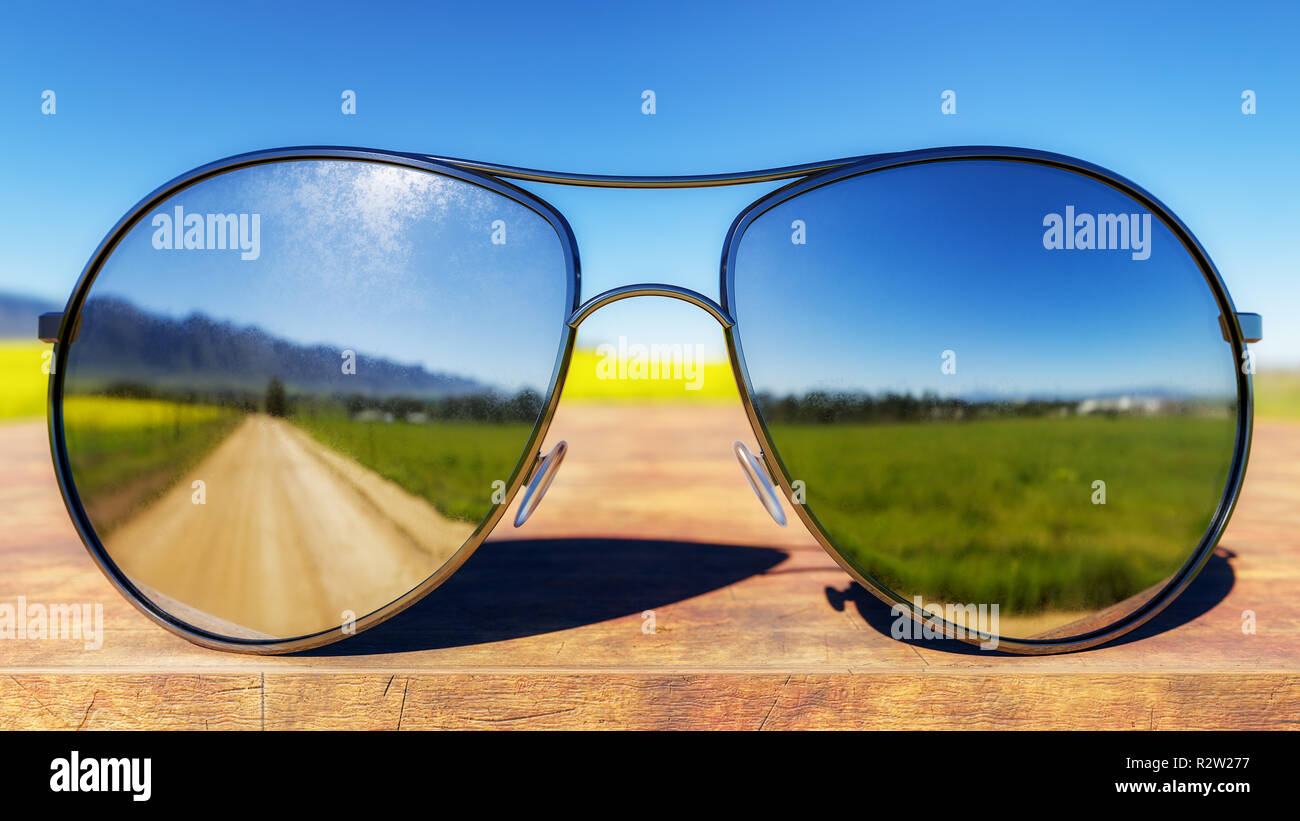 Sunglasses depicting green fields and dirt road on wooden table. 3D Illustration Stock Photo