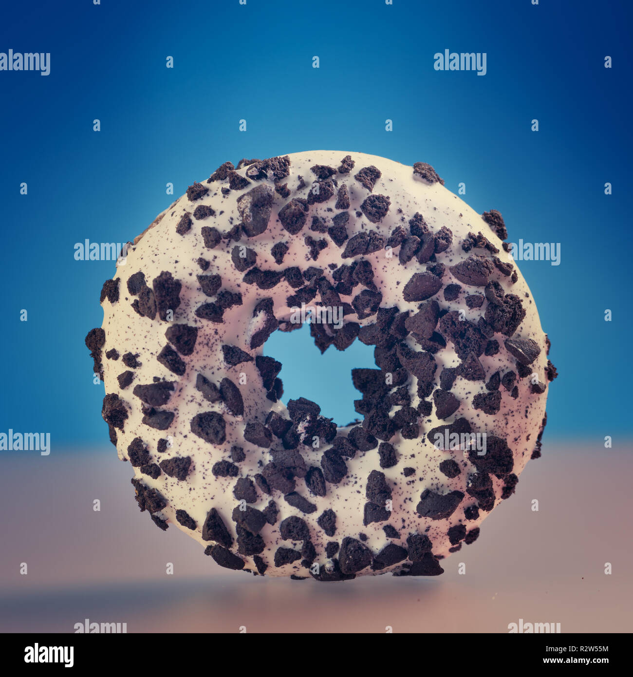 Single round donut on blue background. Stock Photo